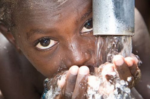Enfant qui boit de l'eau du puit