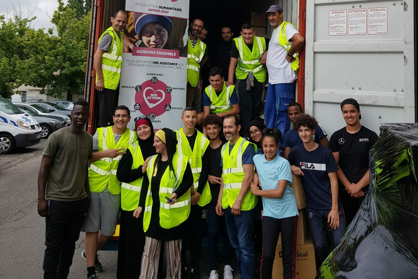 Equipe sauver des vies et ses bénévoles devant un container
